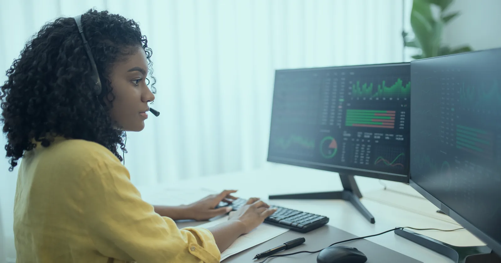 An analyst reviewing performance data on two monitors