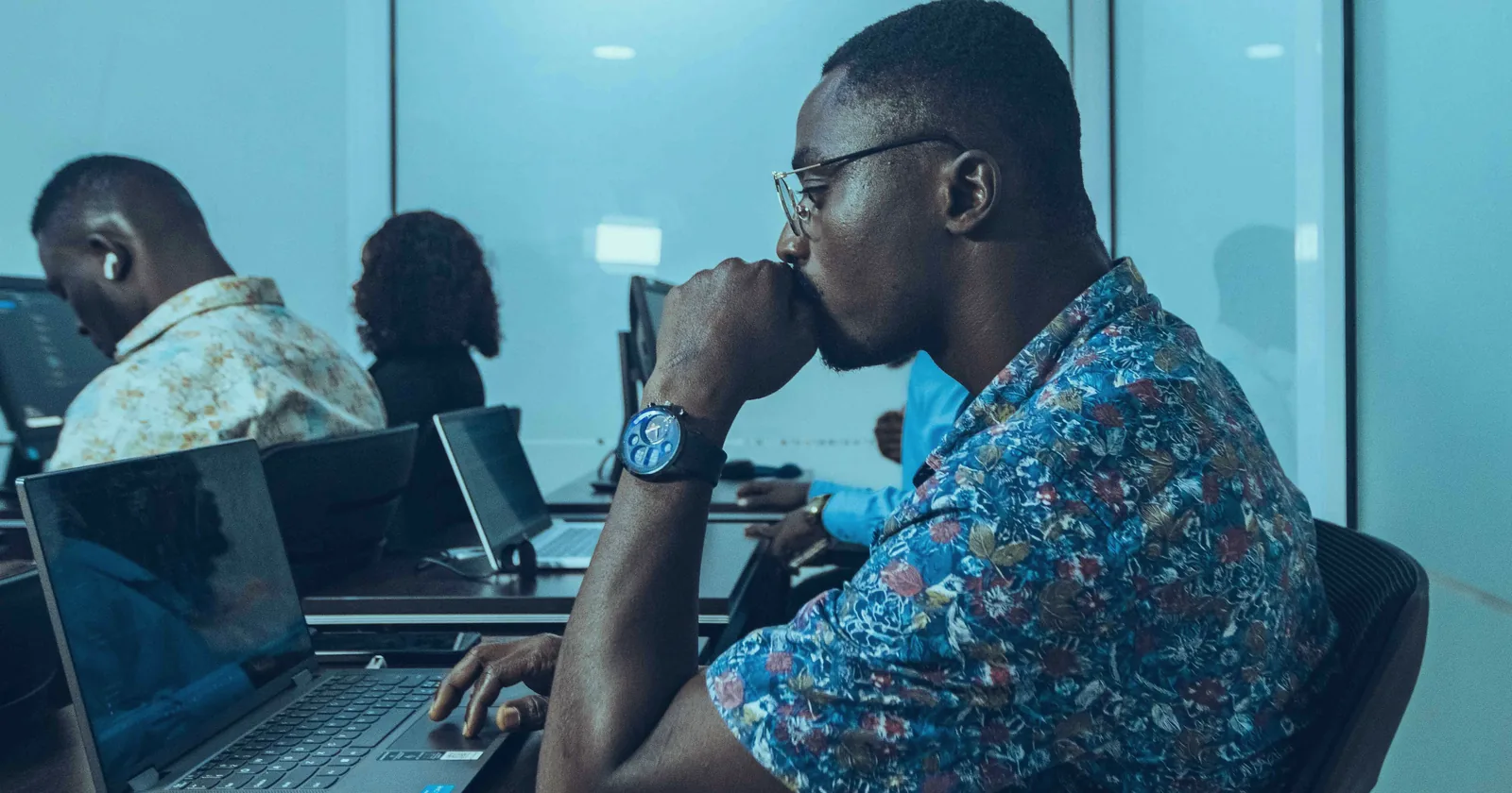 Professionals working at laptops in an IT training workshop in Accra